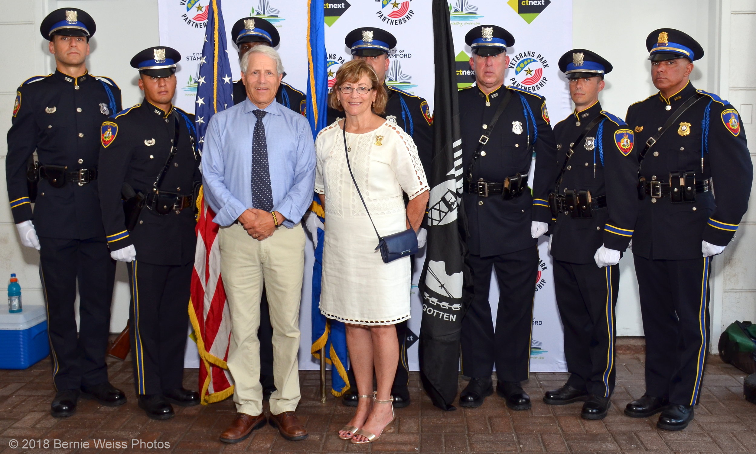 A picture of Stamford's mayor in front of a line of policemen at a groundbreaking ceremony